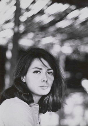 Portrait d'Isabelle Grisi dans les années 1960. La photo est en noir et blanc. L'artiste a les cheveux longs et bruns. Elle tourne la tête vers l'objectif de Charlotte Morel.