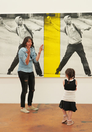 La photo a été prise au MAMCO. Elle représente une mère et ses enfants en train de suivre une visite commentée dans les salles du musée.